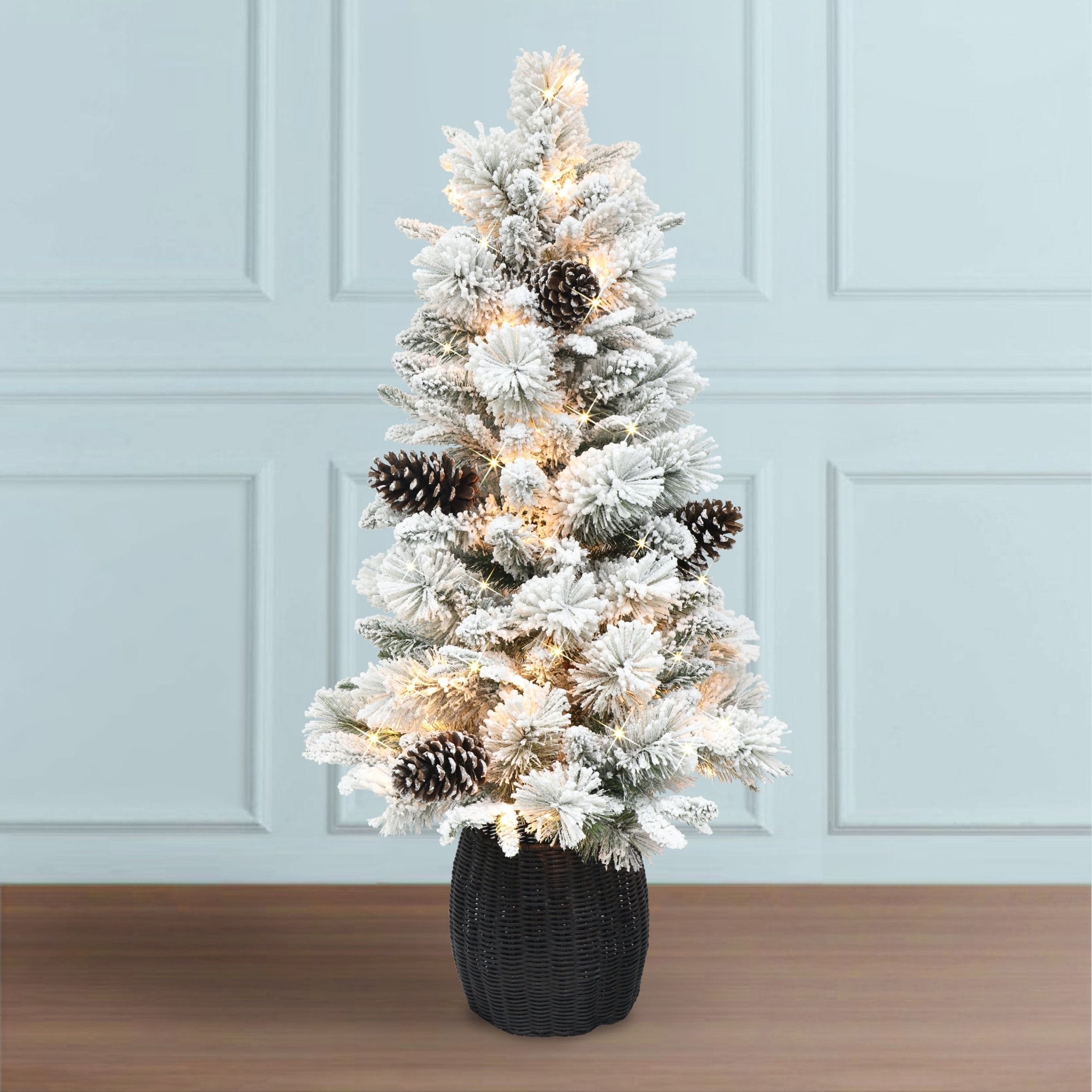 4.5 ft Pre - lit Flocked Potted Tree, 382 Tips, 100 UL Clear Lights, Plastic Rattan - look Base - Tuesday Morning - Faux Trees